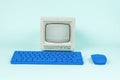 Retro monitor and blue keyboard with mouse on a light background