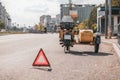 A retro motorcycle with a sidecar without a wheel stands on the edge of the roadway. Warning triangle on the back Royalty Free Stock Photo