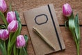 Retro notebook surrounded by pink tulips Royalty Free Stock Photo