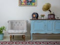Retro off white armchair, vintage wooden light blue sideboard, old phonograph gramophone and vinyl records