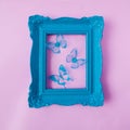 A retro old fashionned pastel blue frame with blue butterflies against pastel pink background. Romantic spring summer design for