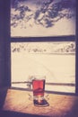 Retro old film style glass of hot tea on wooden table. Royalty Free Stock Photo