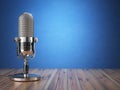 Retro old microphone. Radio show or audio podcast concept. Vintage microphone on blue background.