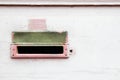 Retro old pink and white mailbox vintage postal box mounted on a cracked, grungy wall