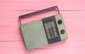 Retro old radio receiver on a pink wooden background. Top view. Outdated technology.