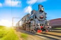 Retro old steam locomotive rushes at speed with a passenger train Royalty Free Stock Photo