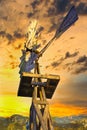 Farm Rustic Windmill Pump Dramatic Clouds and Sky with Mountains Royalty Free Stock Photo