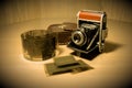 Retro old vintage outdated manual film camera circa 1940s, negative films and leather camera case on wooden table Royalty Free Stock Photo