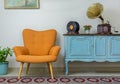 Retro orange armchair and vintage wooden light blue sideboard