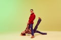 Retro party. Emotional expressive young man and woman in vintage style outfits dancing against gradient green yellow Royalty Free Stock Photo