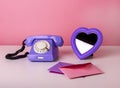 Retro phone on table with heart-formed mirror and envelopes. Valentine s day and love concept