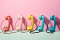 Retro phones in different pastel colors in row over pink background. Generative AI