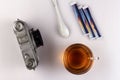 A cup of strong morning tea, on a table with a retro camera, on a white background, a blank for design solutions; close-up.