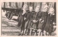 The retro photo shows the group of small girls outsides. Fife little girl in winter time