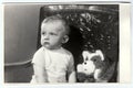 Retro photo of a small boy with teddy bear. Portrait photo was taken in photo studio, circa 1972