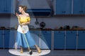 Retro pin up girl housewife holding mop singing and cleaning floor