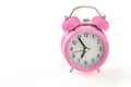 Retro pink alarm clock, with 5 minutes to 7 o`clock on it. Isola