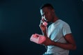 Retro pink colored phone. Futuristic neon lighting. Young african american man in the studio Royalty Free Stock Photo