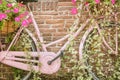 Retro pink woman bicycle with blooming flowers and basket