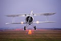 Retro plane fly up over takeoff runway from airport at twilight