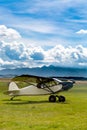 Retro plane landed on meadow in mountains