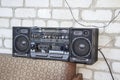Retro portable radio stereo cassette player. Boombox lays outside on the sofa against the white wall from bricks background. Old