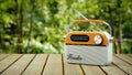 Retro portable radio on wooden table in forest. 3D