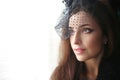 Retro portrait of Elegant brunette woman wearing in hat with veil looking out window. Royalty Free Stock Photo