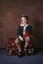 Retro portrait of a little girl in a jacket with a leather camera case. studio. brown background Royalty Free Stock Photo