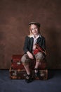 Retro portrait of a little girl in a jacket with a leather camera case. studio. brown background