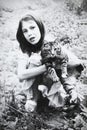 Retro portrait of Soviet girl with cat in hands. Vintage black and white paper photo. Early 1990s. Old surface, soft focus. Royalty Free Stock Photo