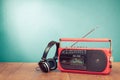 Retro radio cassette recorder and headphones on wooden table front mint blue background. Vintage style filtered photo