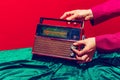 Retro radio. Female hand touching radioreceiver  on red and green background. Vintage, retro fashion style. Pop Royalty Free Stock Photo