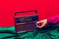 Retro radio. Female hand touching radioreceiver  on red and green background. Vintage, retro fashion style. Pop Royalty Free Stock Photo