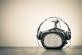 Retro radio, headphones and old microphone on wooden desk. Vintage style sepia photo