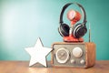 Retro radio, microphone and headphones, star on wooden table front mint blue background. Vintage style filtered photo Royalty Free Stock Photo