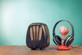 Retro radio, microphone and headphones on wooden table front mint blue background. Vintage style filtered photo Royalty Free Stock Photo