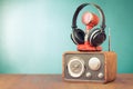 Retro radio, microphone and headphones on wooden table front mint blue background. Vintage style filtered photo Royalty Free Stock Photo