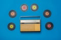 Retro radio and multicolored vinyl discs on a blue background. Radio engineering of the past time.