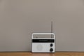 Retro radio receiver on wooden table against grey background Royalty Free Stock Photo
