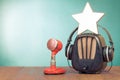 Retro radio, star, red microphone and headphones on wooden table front mint blue background. Vintage style photo Royalty Free Stock Photo