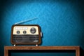 Retro radio on wood table with blue wallpaper