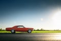 Retro red car standing on asphalt road at sunset Royalty Free Stock Photo