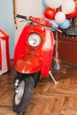 Retro red scooter  in oldschool vintage interior with air balloons. Royalty Free Stock Photo