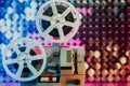 Retro reel with film rotating on sequins kinetic wall, colorful light. Old-fashioned 8mm projector playing in decorated Royalty Free Stock Photo