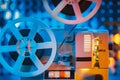 Retro reel with film rotating on sequins kinetic wall, colorful light. Old-fashioned 8mm projector playing in decorated Royalty Free Stock Photo