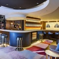 A retro, 1970s-themed home bar with lava lamps, shag carpet, and a sunken seating area4, Generative AI