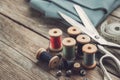 Retro sewing items - tailoring scissors, thimbles, buttons, wooden thread spools, measuring tape and green fabric Royalty Free Stock Photo