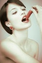 Retro shot of a woman biting a chili pepper