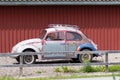 Retro small and old shabby car behind fence Royalty Free Stock Photo